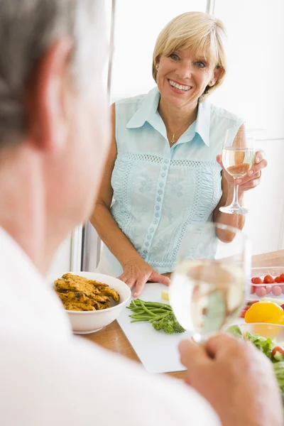 Mulher conversando com o marido como ela prepara uma refeição, hora da refeição — Fotografia de Stock