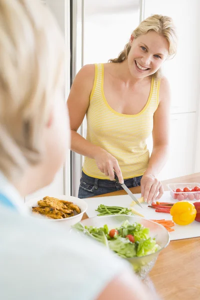 Kvinnan talar till vän samtidigt förbereda måltiden, matdags — Stockfoto