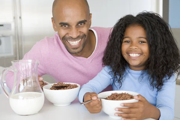 Vader zit met dochter als ze ze eten ontbijt — Stockfoto