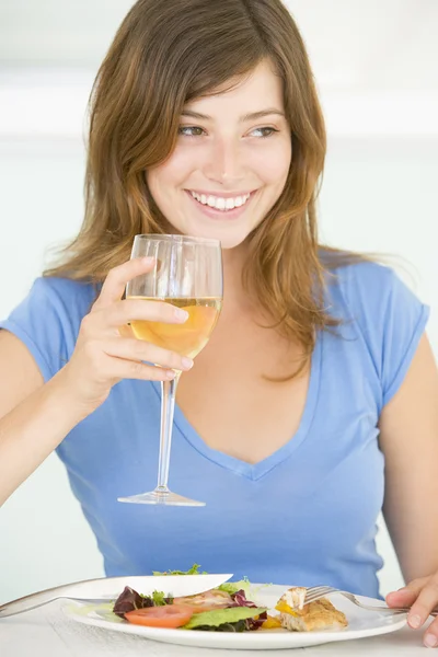 Joven mujer disfrutando de la comida, a la hora de comer con una copa de vino —  Fotos de Stock