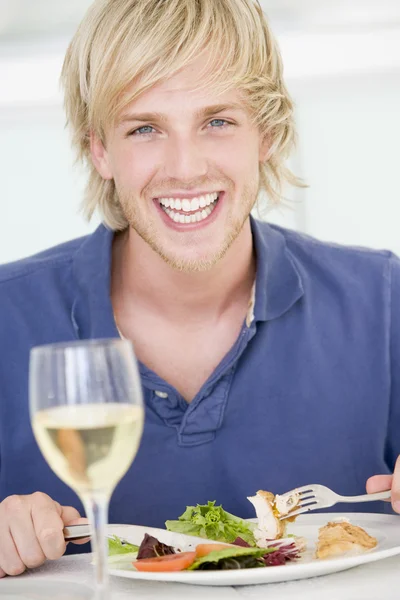 Joven disfrutando de la comida, a la hora de comer con una copa de vino — Foto de Stock