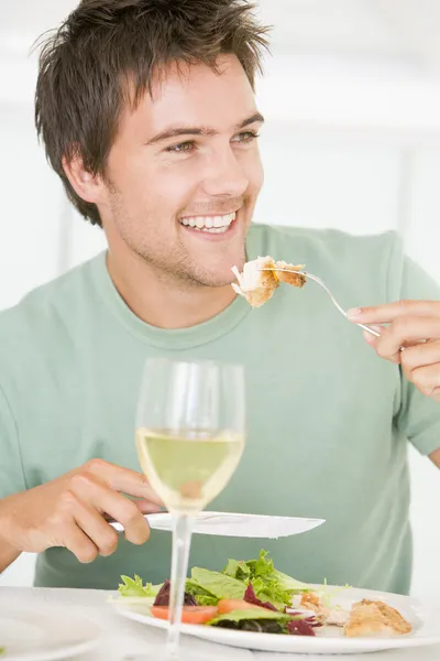 Jovem desfrutando de refeição, hora da refeição com um copo de vinho — Fotografia de Stock