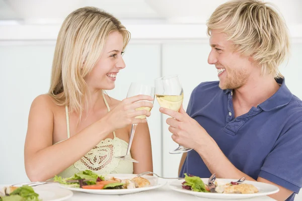Молодая пара наслаждается едой, едой со стаканом вина — стоковое фото