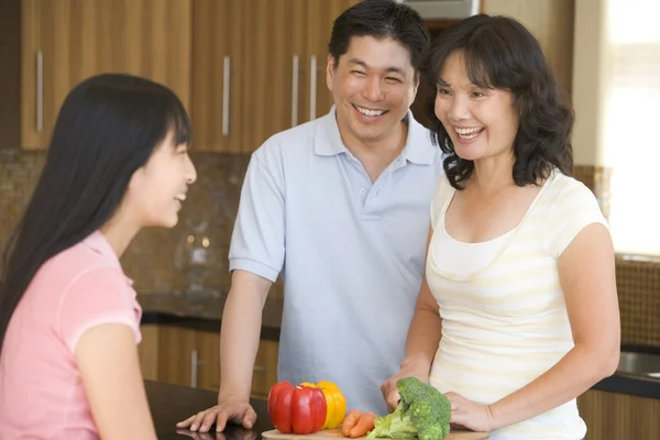 Familjen skrattar medan du förbereder måltid, matdags — Stockfoto