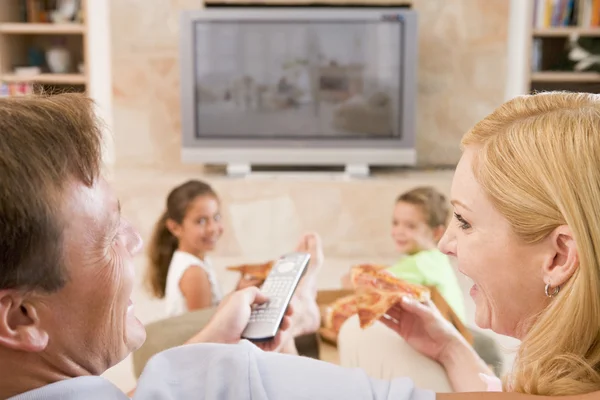 Casal desfrutando de pizza na frente da TV — Fotografia de Stock