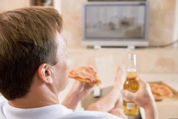 Bira ve pizza tv önünde tadını çıkarıyor adam — Stok fotoğraf