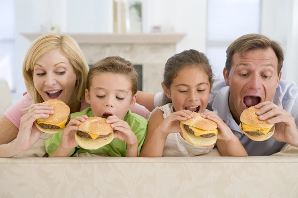 Rodina jíst cheeseburgery dohromady — Stock fotografie