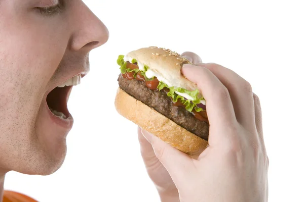 Чоловік кусає чізбургер — стокове фото