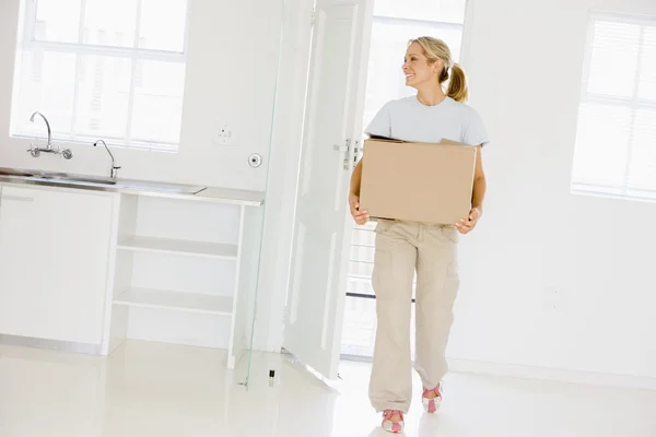 Mujer con caja moviéndose en un nuevo hogar sonriendo —  Fotos de Stock
