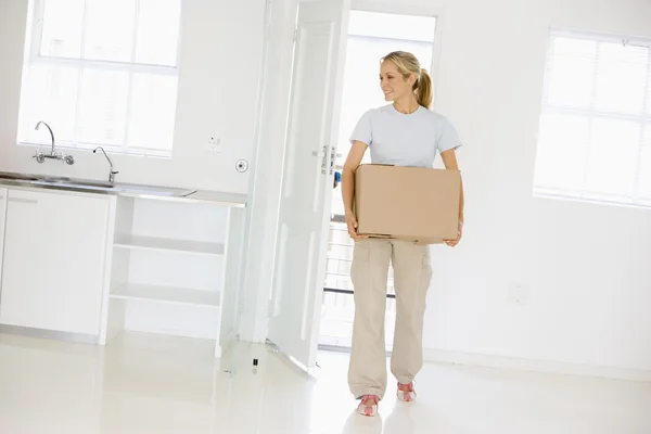 Mulher com caixa movendo-se para casa nova sorrindo — Fotografia de Stock