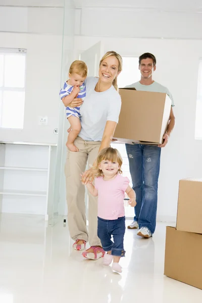 Famiglia con scatola trasferirsi in una nuova casa sorridente — Foto Stock