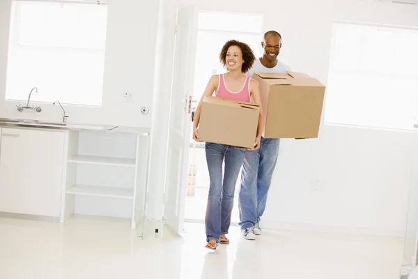Paar mit Kisten zieht lächelnd in neues Zuhause ein — Stockfoto