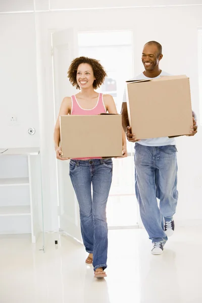 Casal com caixas que se movem para casa nova sorrindo — Fotografia de Stock
