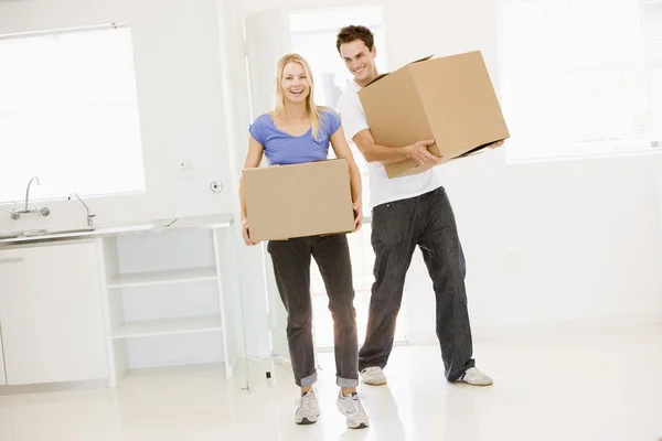 Pareja con cajas moviéndose a un nuevo hogar sonriendo —  Fotos de Stock