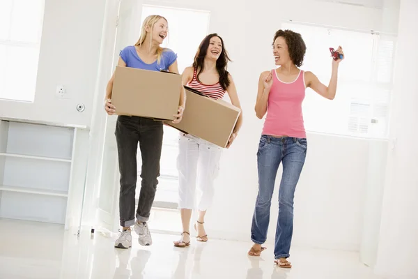 Drei Freundinnen ziehen lächelnd in ihr neues Zuhause — Stockfoto