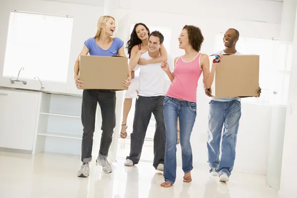 Group of friends moving into new home smiling — Stock Photo, Image