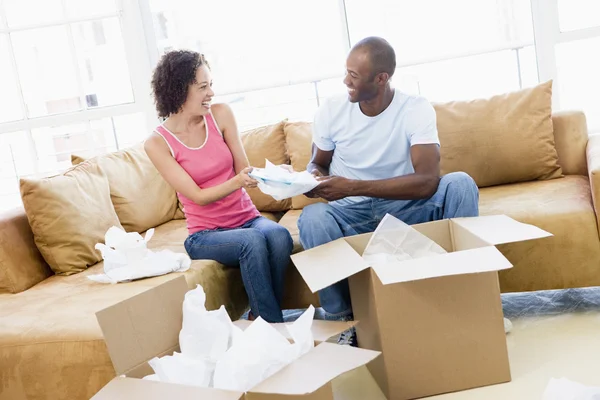Paar packt lächelnd Kisten im neuen Zuhause aus — Stockfoto