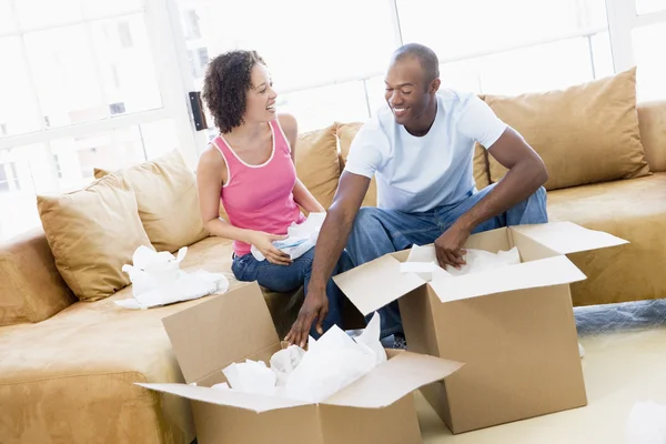 Casal desembalagem caixas em nova casa sorrindo — Fotografia de Stock