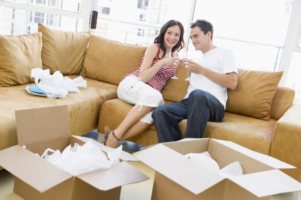 Paar entspannt lächelnd mit Champagner an Kisten im neuen Zuhause — Stockfoto