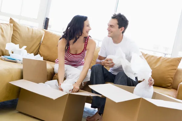 Couple unpacking boxes in new home smiling — Stock Photo, Image