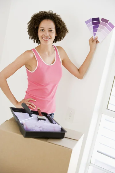 Woman with paint swatches in new home smiling — Stock Photo, Image