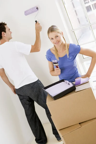 Couple painting room in new home smiling — Stock Photo, Image