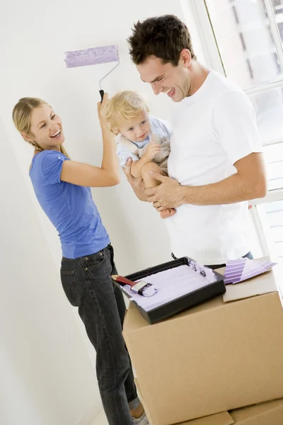 Family painting room in new home smiling — Stock Photo, Image
