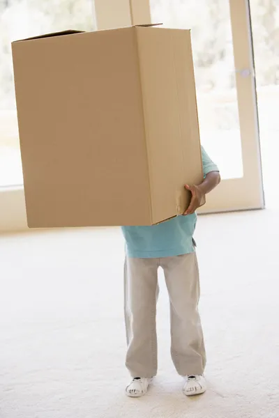 Мальчик держит коробку в новом доме — стоковое фото