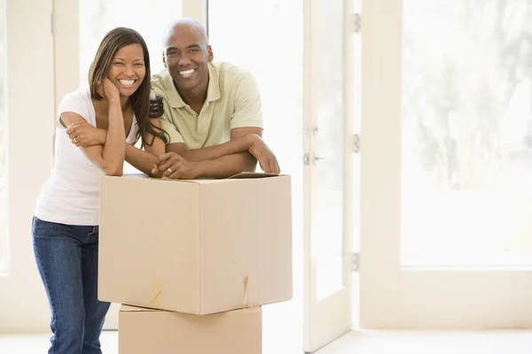 Casal com caixas em nova casa sorrindo — Fotografia de Stock
