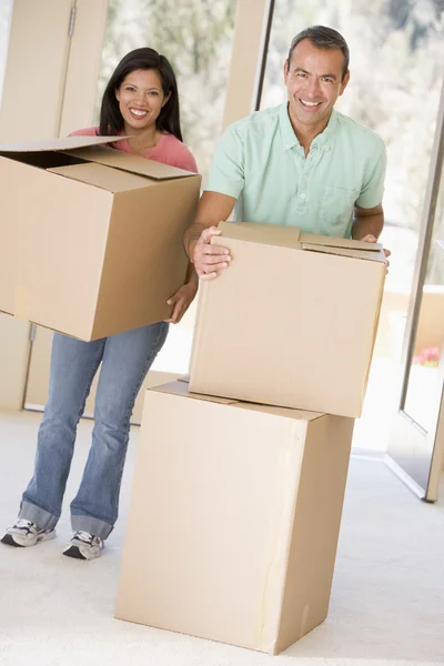 Coppia con scatole che si trasferiscono in una nuova casa sorridente — Foto Stock