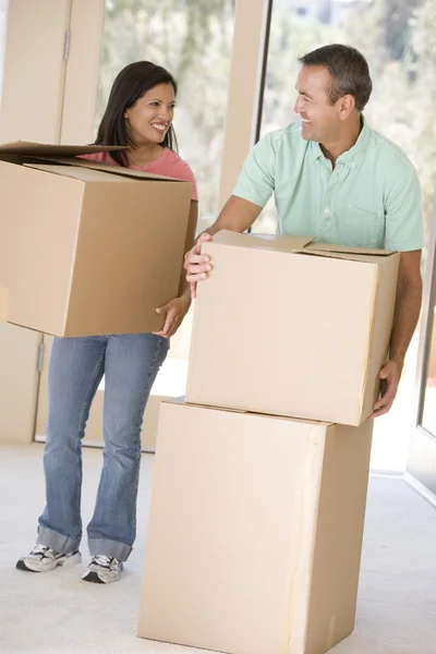 Couple with boxes moving into new home smiling — Stock Photo, Image