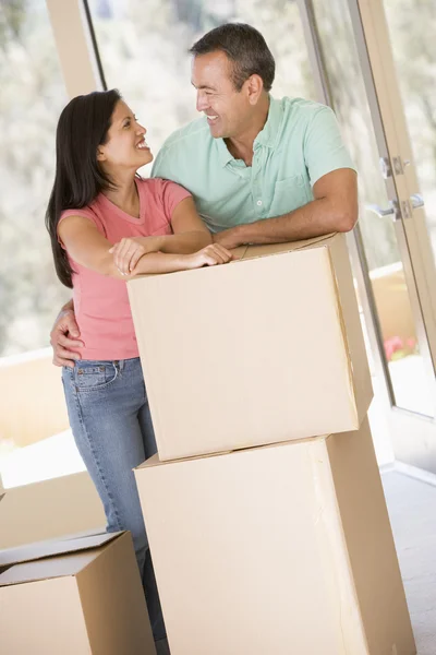 Paar mit Schachteln im neuen Zuhause lächelt — Stockfoto