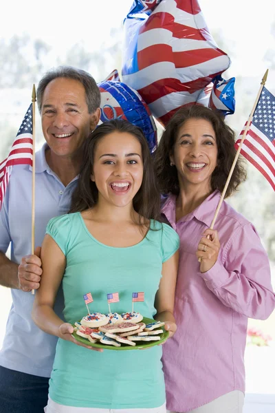 Famiglia all'aperto il 4 luglio con bandiere e biscotti sorridenti — Foto Stock