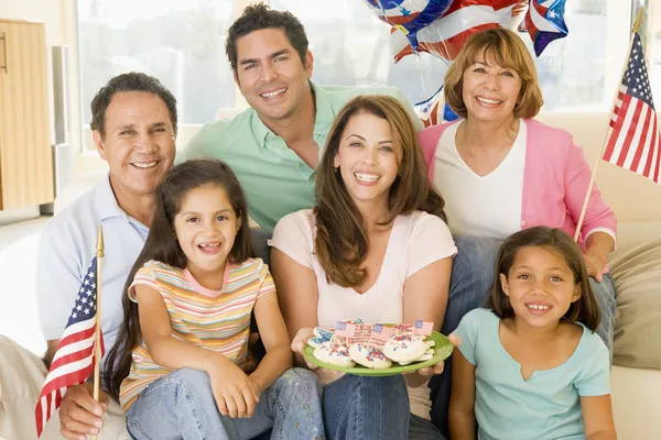 Rodziny w salonie czwartego lipca z flagi i ciasteczka s — Zdjęcie stockowe