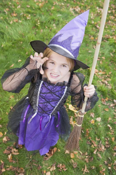 Jong meisje buitenshuis in heks kostuum op halloween — Stockfoto