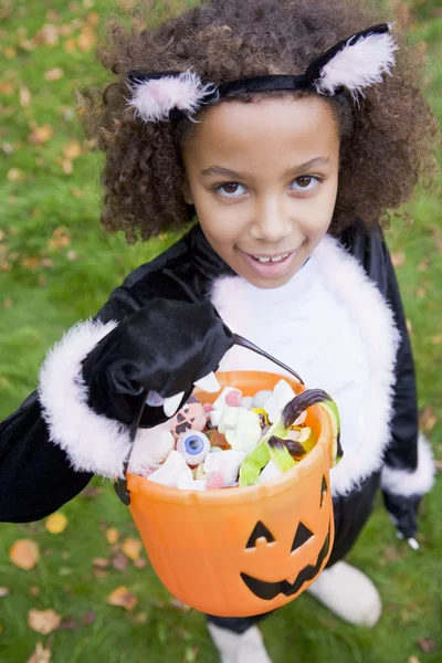 屋外猫衣装ハロウィーンのキャンディーを保持している上で若い女の子 — ストック写真