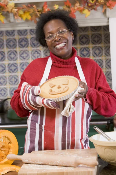 Mulher na cozinha fazendo guloseimas de Halloween e sorrindo — Fotografia de Stock