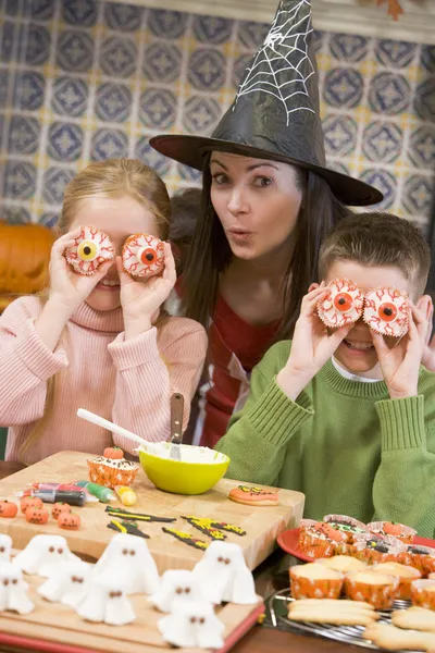 Madre y dos niños en Halloween jugando con golosinas y smi — Foto de Stock