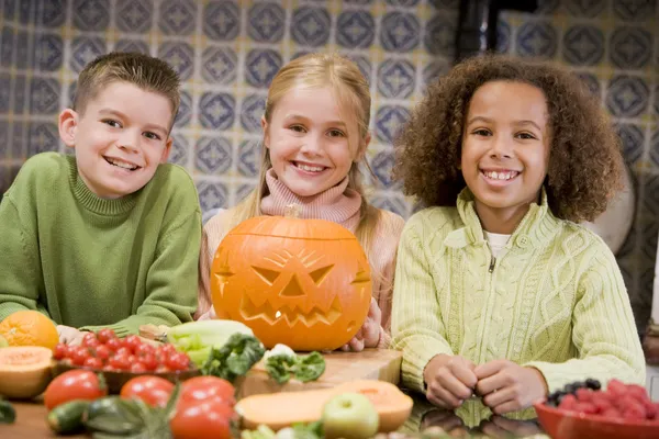 三个年轻的朋友在万圣节与杰克 o 灯笼和食物 sm — 图库照片