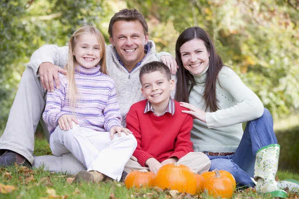 Familie Zittend Het Gras Met Pumpkins Glimlachen — Stockfoto