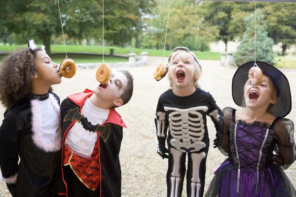 Quatre Jeunes Amis Sur Halloween Costumes Manger Des Beignets Hangin — Photo