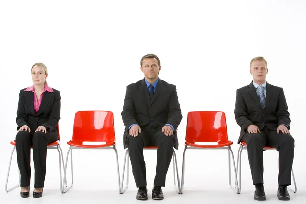 Три бізнес, сидячи на червоний пластиковими сидіннями — стокове фото