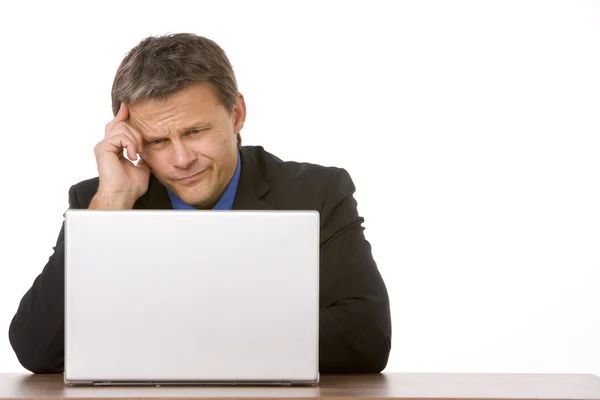 Homme d'affaires fronçant les sourcils tout en regardant l'ordinateur portable — Photo