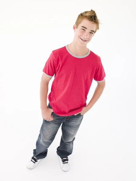 Nastoletni chłopiec z rękami w kieszeniach uśmiechający się — Zdjęcie stockowe