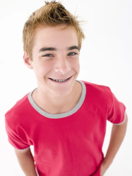 Nastoletni chłopiec z rękami w kieszeniach uśmiechający się — Zdjęcie stockowe