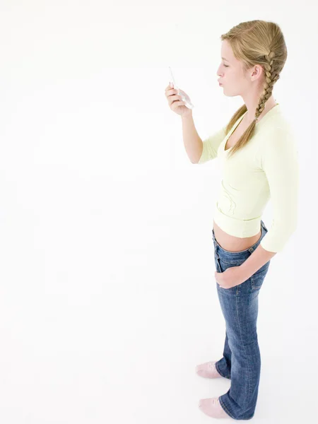 Tonårig flicka tittar på mobiltelefon och puckering — Stockfoto