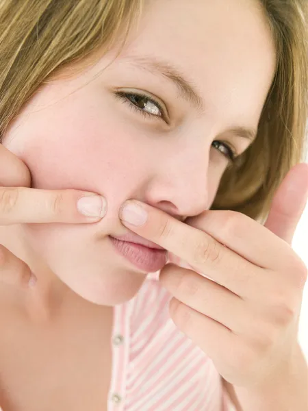 Teenage girl popping zit on face — Stock Photo, Image