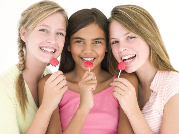 Three girl friends with suckers smiling — Stock Photo, Image
