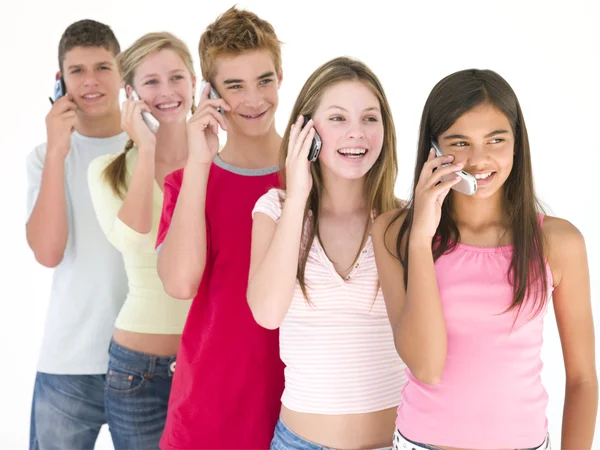Rij Van Vijf Vrienden Mobiele Telefoons Glimlachen — Stockfoto