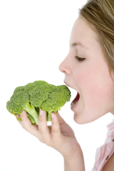 Adolescente comendo brócolis — Fotografia de Stock